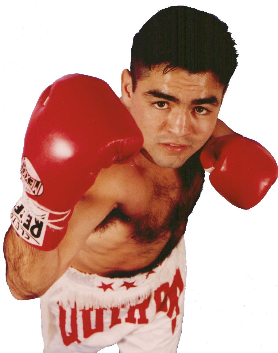 Robert Quiroga in his fighting stance, wearing red gloves and white trunks with QUIROGA across the waistband